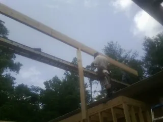 Carpenter setting a ridge beam over a new addition frame — Ice Dam Removal by Roofing Brothers in Mooreland