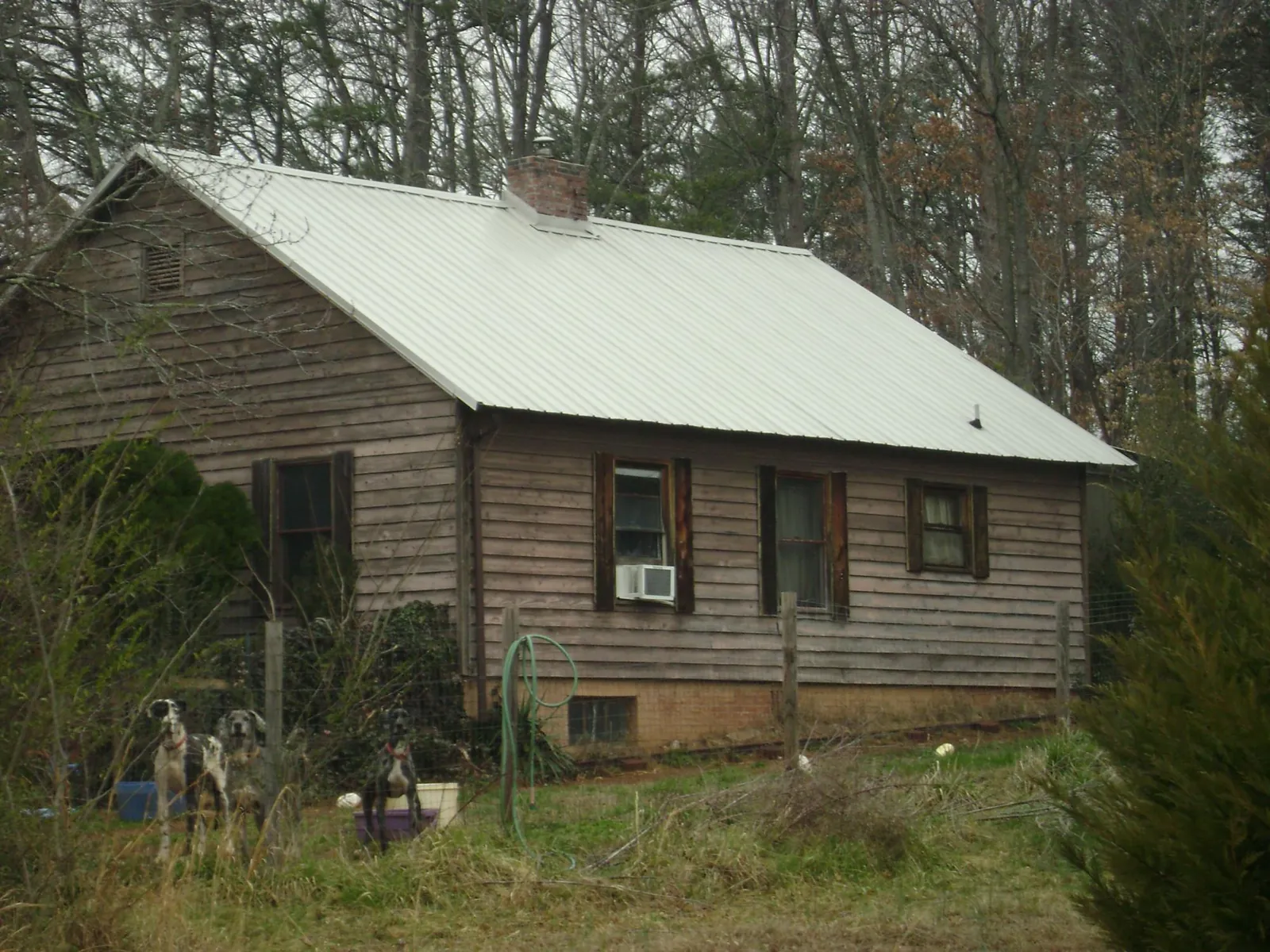 White metal roof on an old wood sided farmhouse, from a Metal Roof Installation job in Mooreland